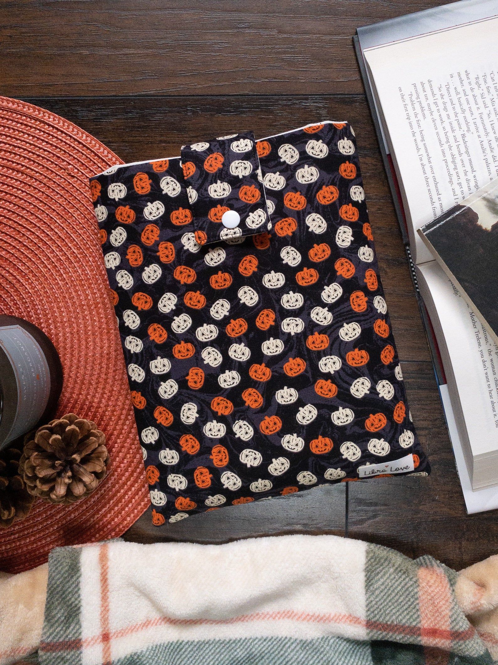 Image of black book sleeve dotted in orange and white pumpkins. 