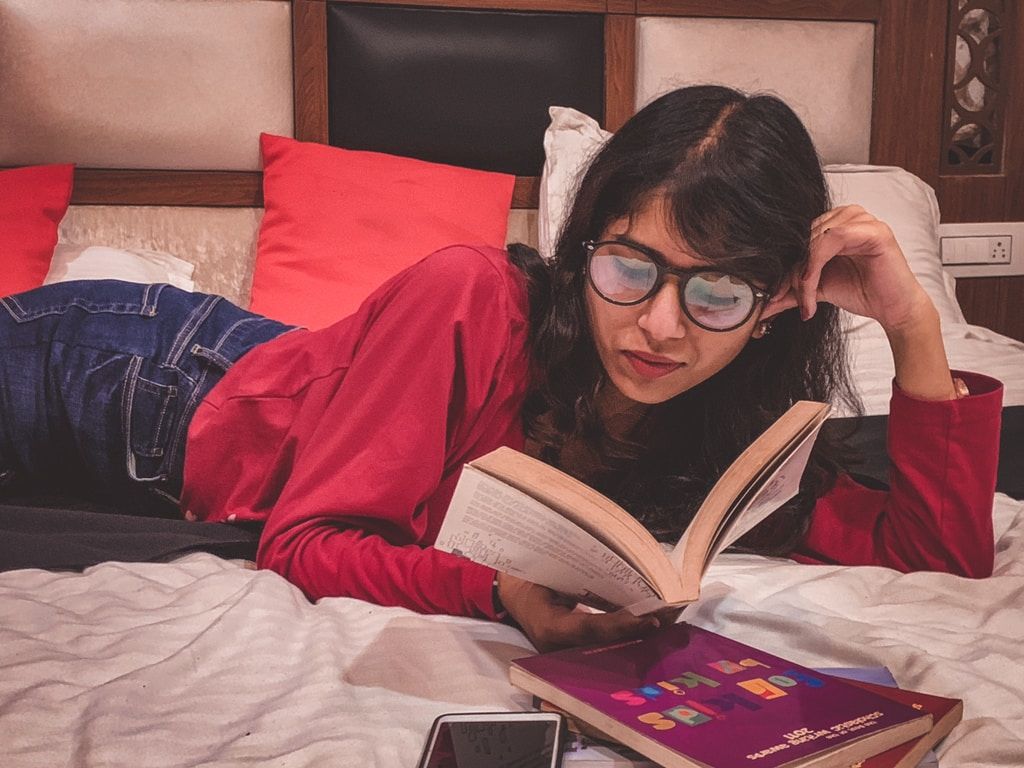 a woman reading a book in bed