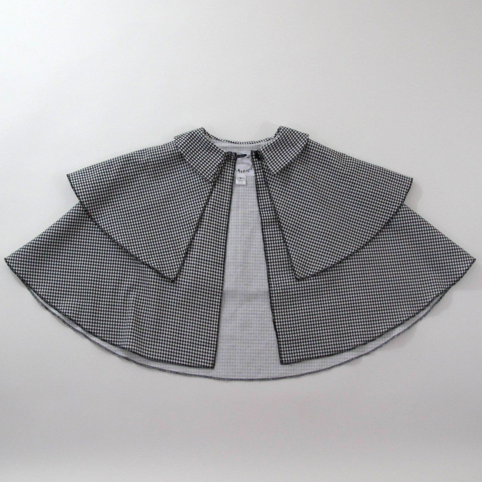 Image of a houndstooth cape. 