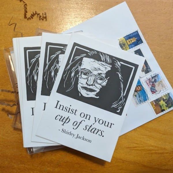 a linocut portrait of the author, a white woman wearing glasses, with the words "insist on your cup of stars"