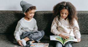 two kids reading on couch