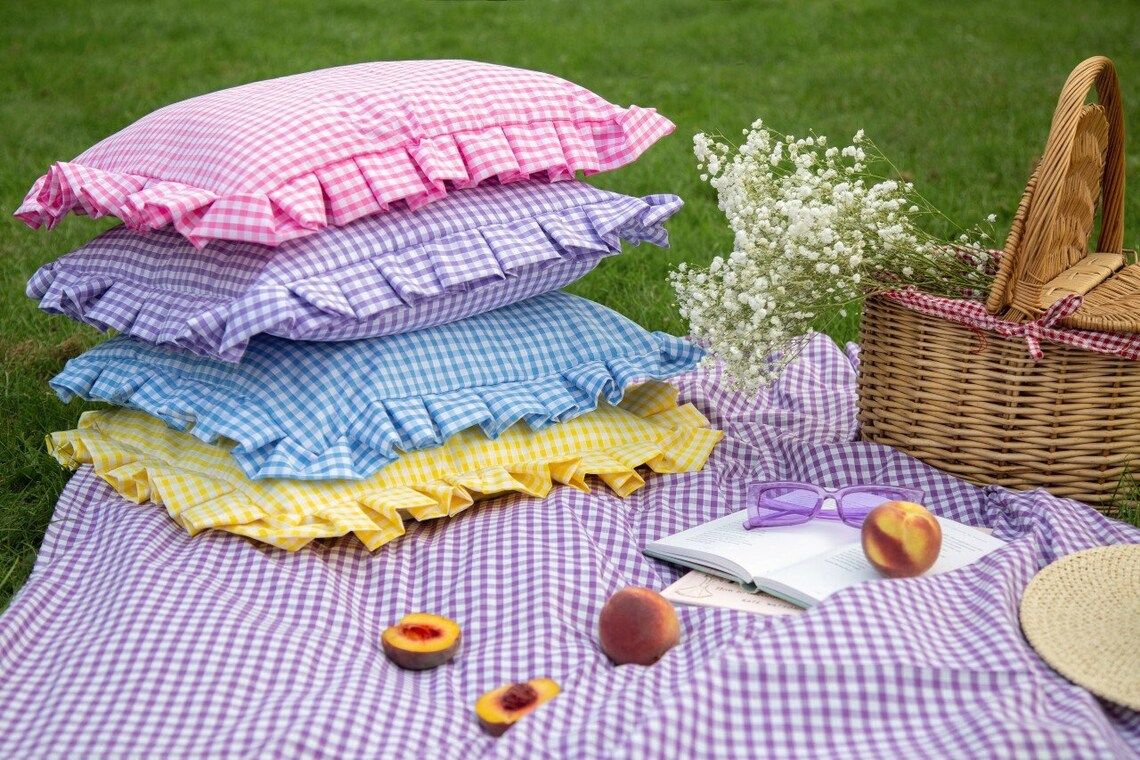 Gingham cushion covers on a blanket on the grass