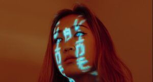 Futuristic image of young Asian woman with orange hair and milky eyes and Chinese writing characters made of light over her face