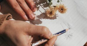 person drawing a flower on lined paper