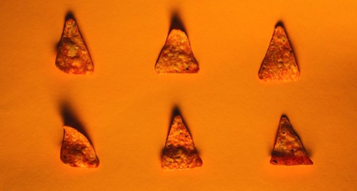 six individual Doritos chips against an orange background