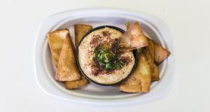 Image of a bowl of hummus surrounded by flat bread
