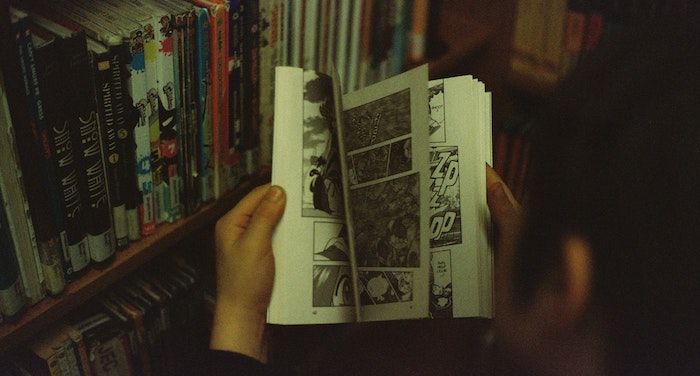 Image of young person flipping through a comic