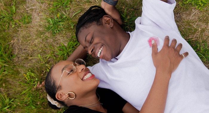 Image of Black couple snuggling in the grass