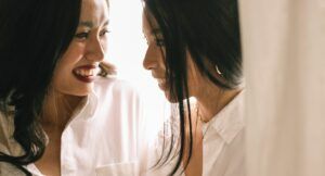 Image of two Asian women nearly kissing