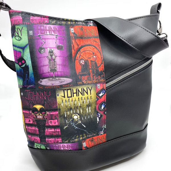 A leatherette purse. One half is black, and the other half is a colorful composite of Johnny the Homicidal Maniac comic book covers.