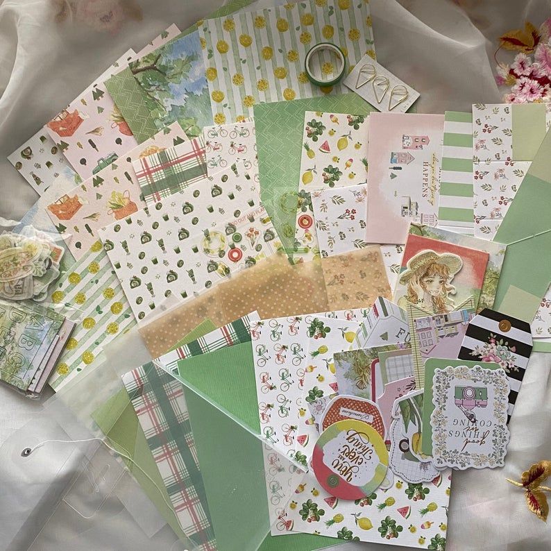 Stationary kit with numerous papers in a range of yellow and green shades and patterns. 