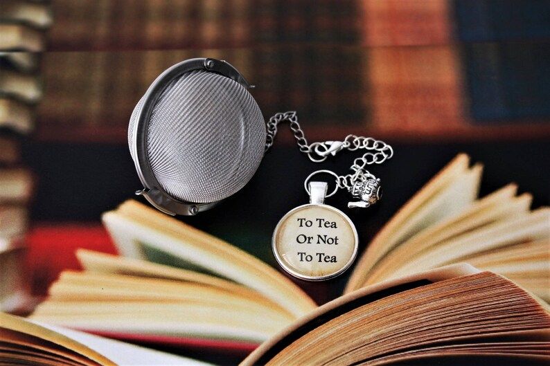 ball style tea infuser with a little tea mug charm and a cabochon that says to tea or not to tea