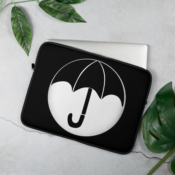 A black and white laptop sleeve with the Umbrella Academy logo on it.