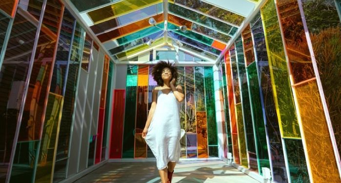 image of woman walking through colorful stained glass hallway