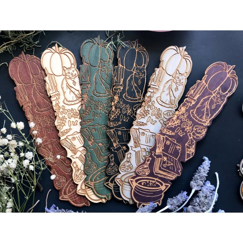 Wooden bookmarks featuring cats, cauldrons, pumpkins, and other witchy ephemera. 