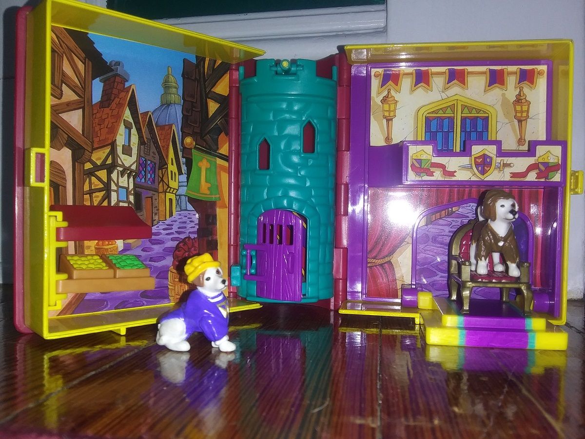 Author photo of a children's playset depicting a medieval exterior on one side and a palace on the other. Two Wishbone figurines sit among the scenes.