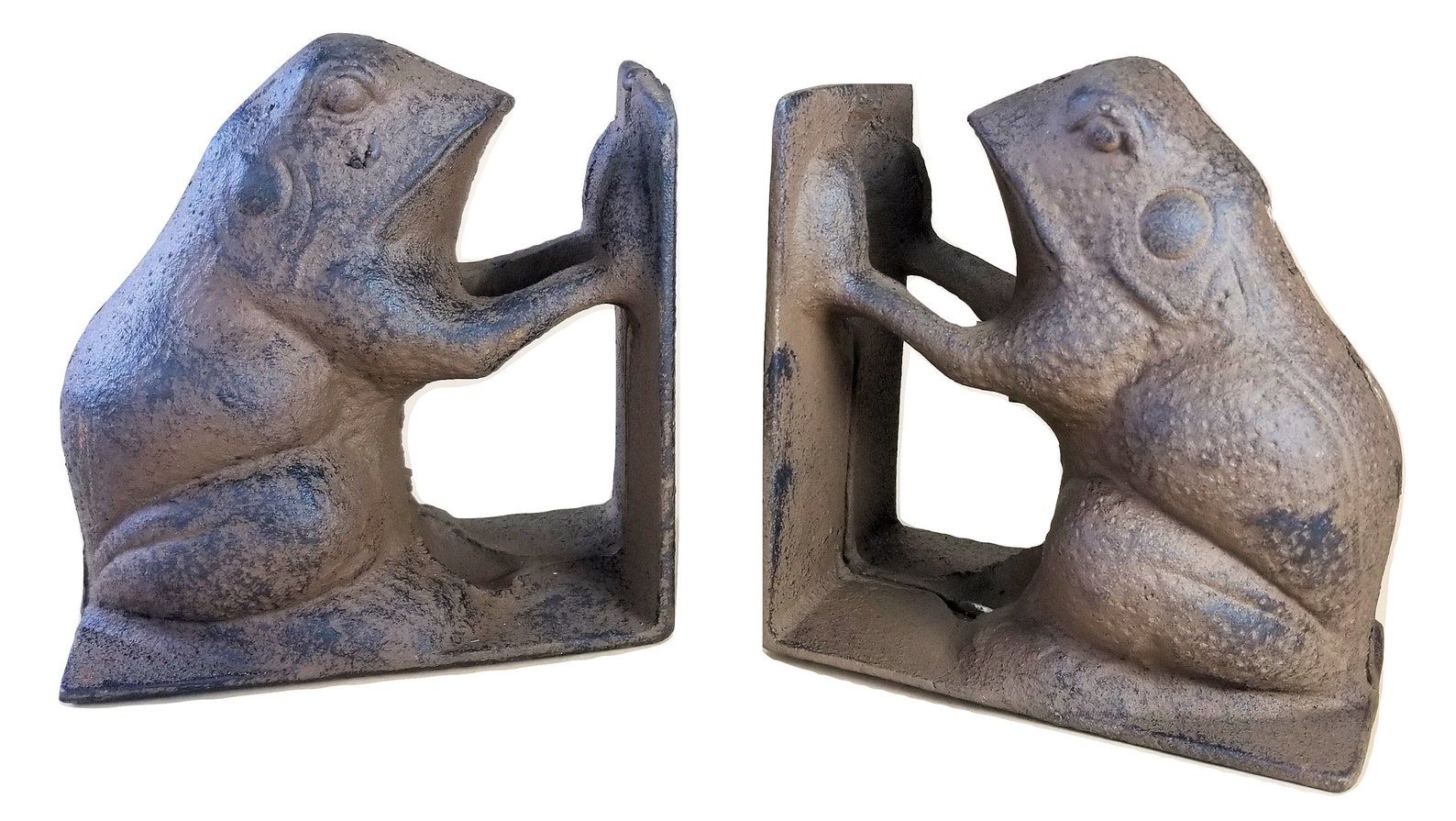 Two cast iron bookends shaped like large brown toads with two of their legs up in the air.
