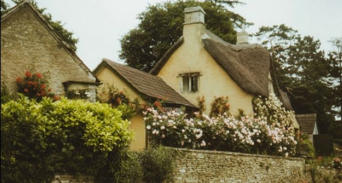 image of an English countryside cottage with flowers and greenery