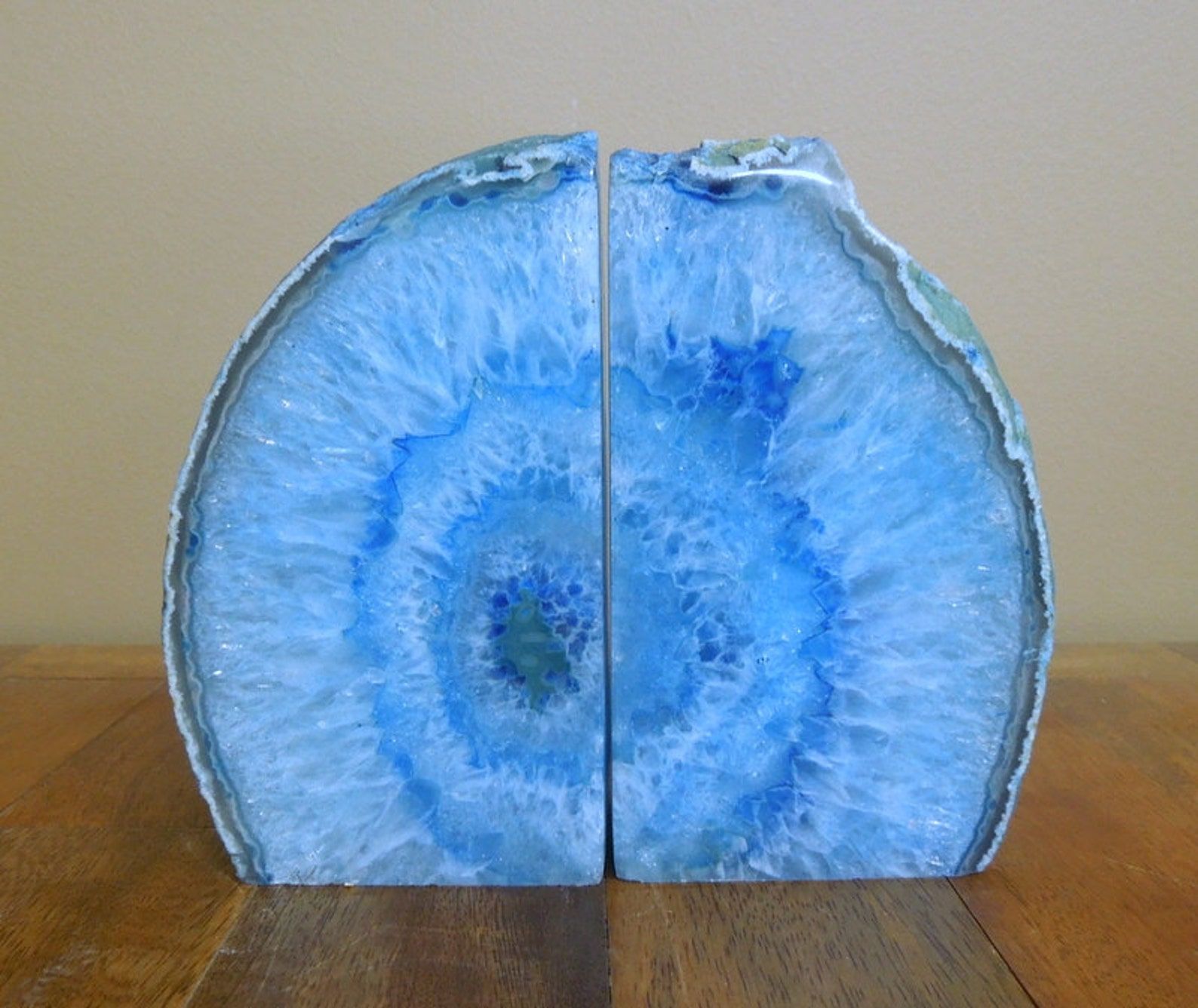 Two sparkly, bright blue agate geode bookends; the two halves together form a round shape.