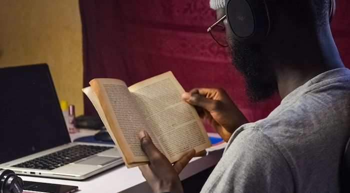 Image of a black man reading a book.