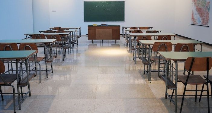 Image of desks and chalk board inside a classroom