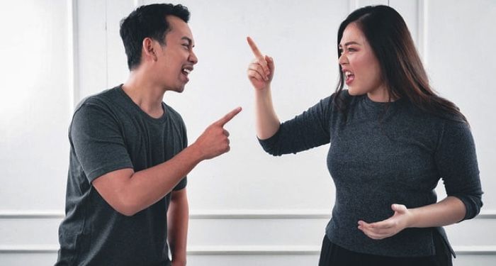 man and woman pointing fingers at each other arguing