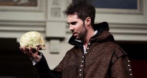 a stage actor playing Hamlet, holding.a skull