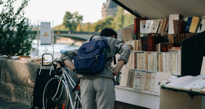 a person browsing a riverfront bookshop in Paris, France