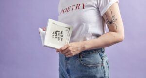 person with poetry shirt holding book