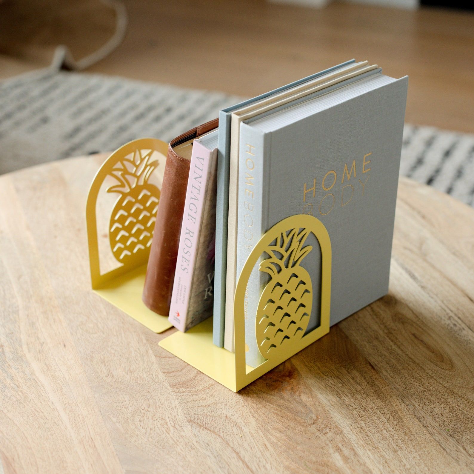 Two rounded yellow metal bookends shaped like pineapples.