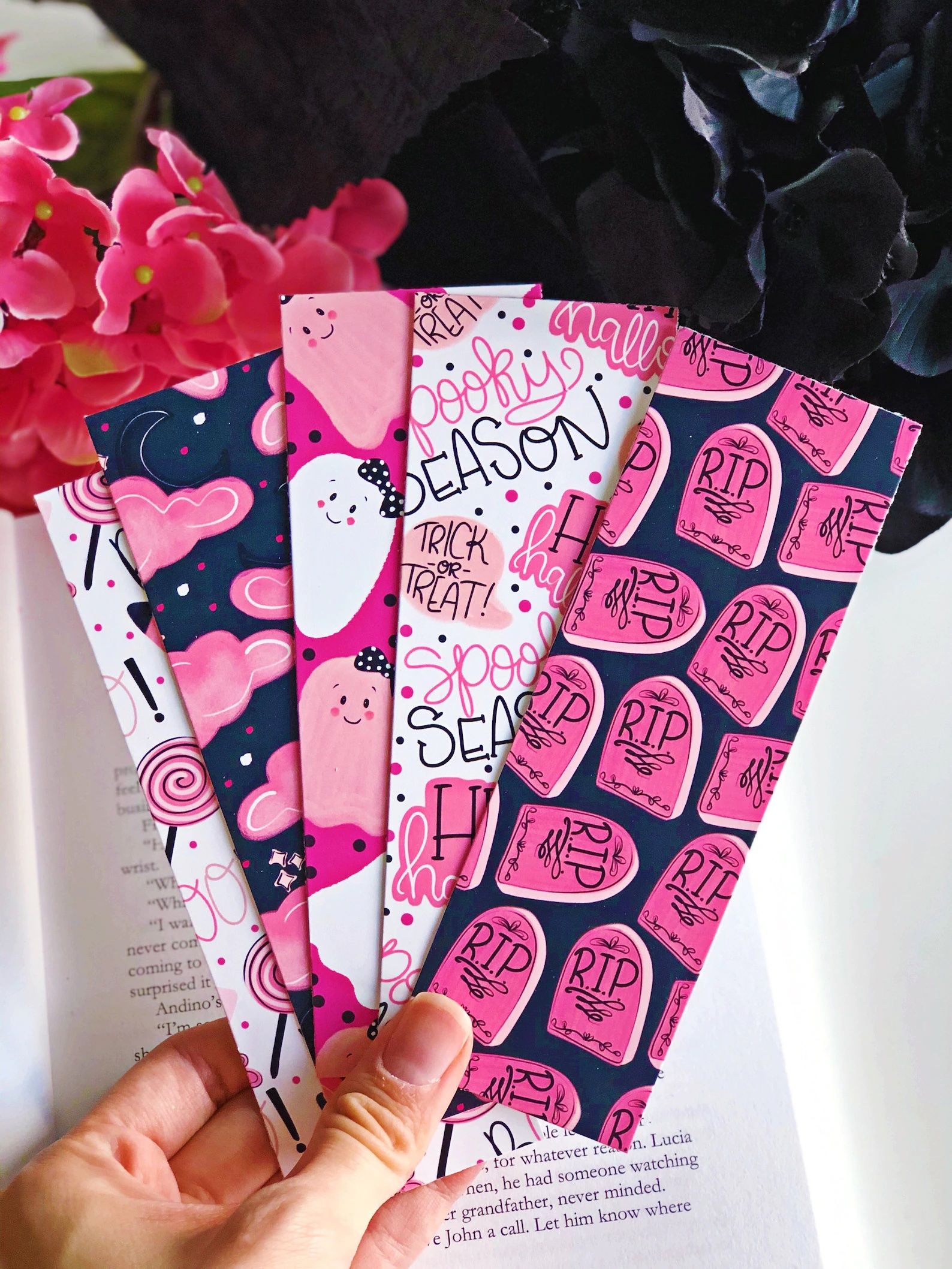 a collection of five pink, white, and navy blue bookmarks with spooky season and ghost motifs