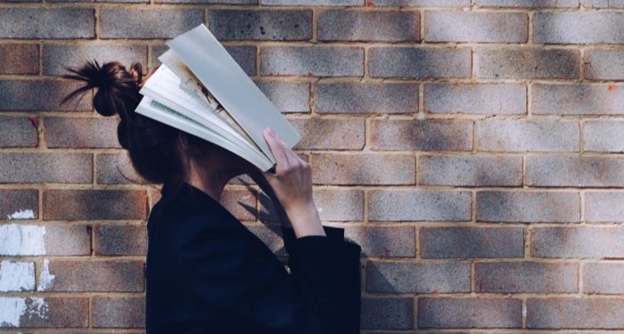a person holding a book up to their face