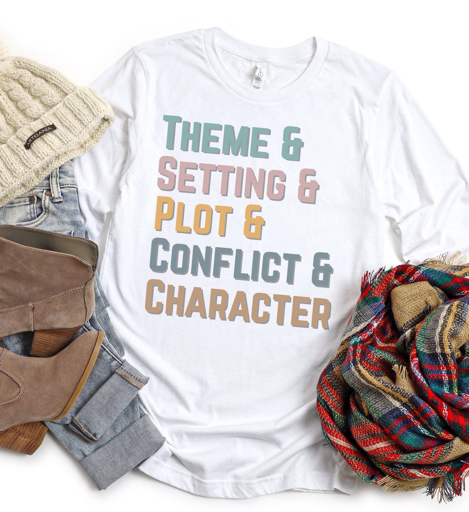 Image of a white t-shirt which reads "theme & setting & plot & conflict & character" in pastel colors. 