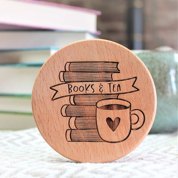 wooden coaster engraved with stack of books and cup of tea