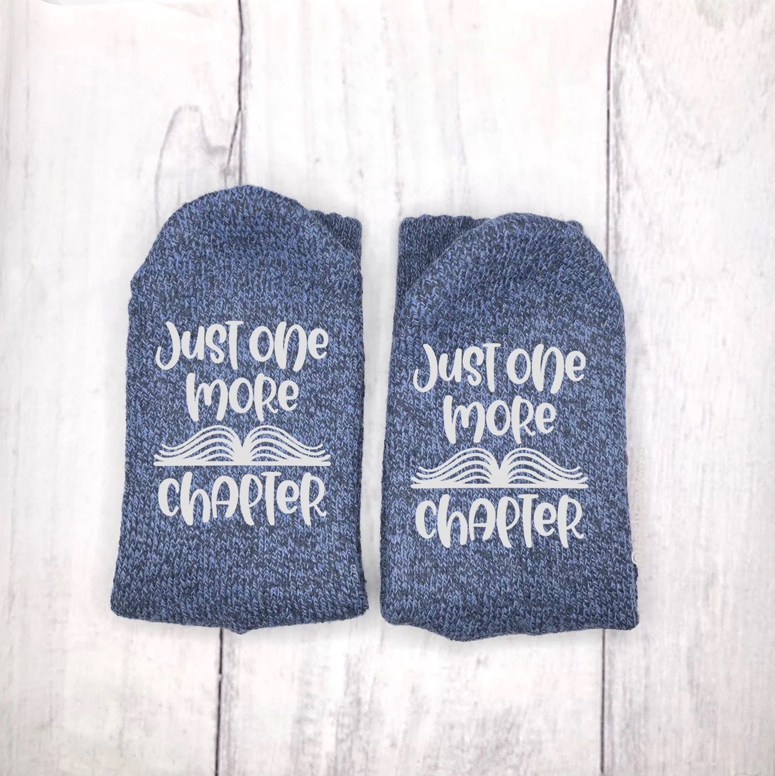 Gifts for book lovers: Blue fuzzy socks with the words, "just one more chapter."