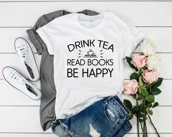 a photo of a shirt saying DRINK TEA, READ BOOKS, BE HAPPY next to some flowers and shoes and jeans