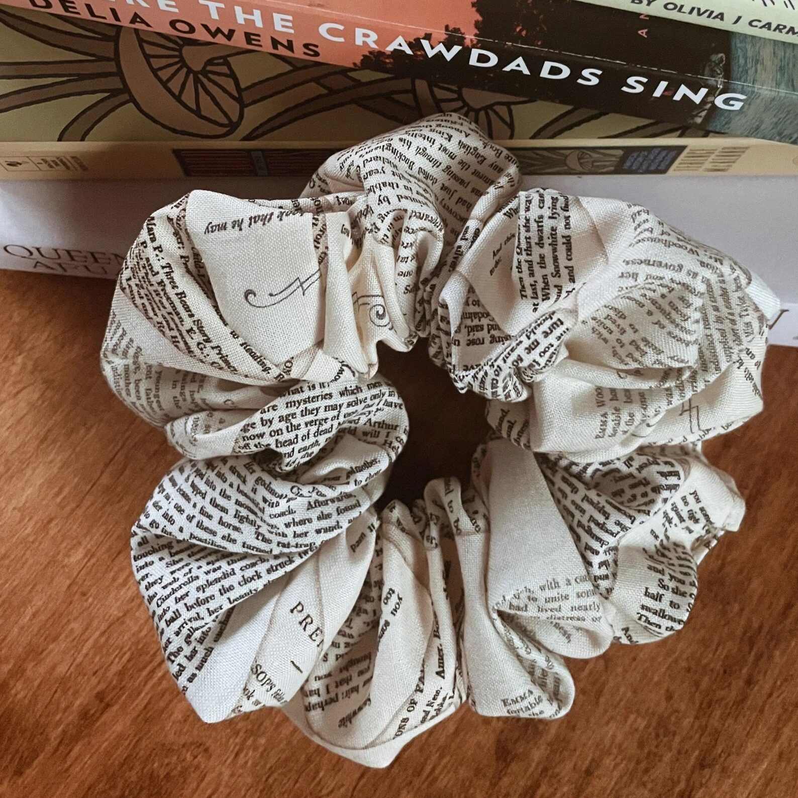 A white scrunchie is decorated with black text.