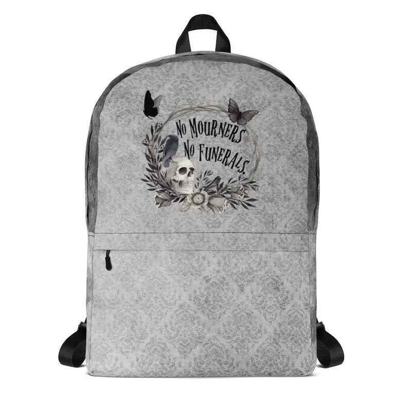 Gift for book lover: Gray backpack with butterflies, crows, and a skull embroidered on it with the text, "no mourners no funerals."