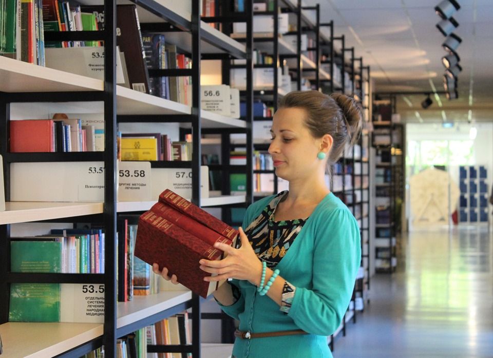 Image of a woman library worker shelving