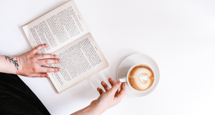 a photo of an open book and mug of coffee