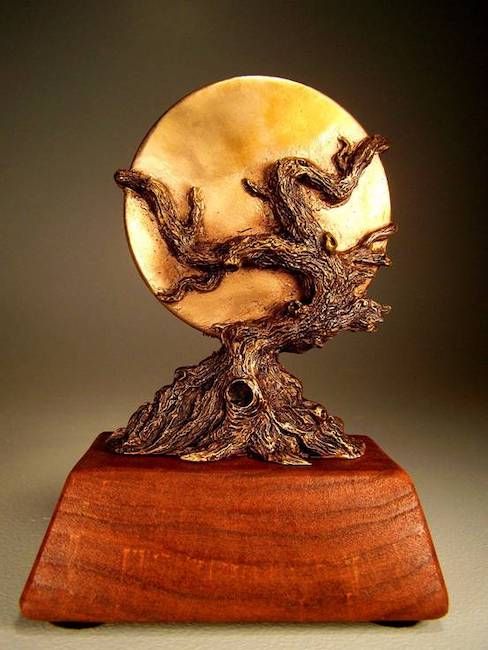 The World Fantasy award statue. It is a trapezoidal, teddish wood base with a gnarled tree holding a golden moon. 
