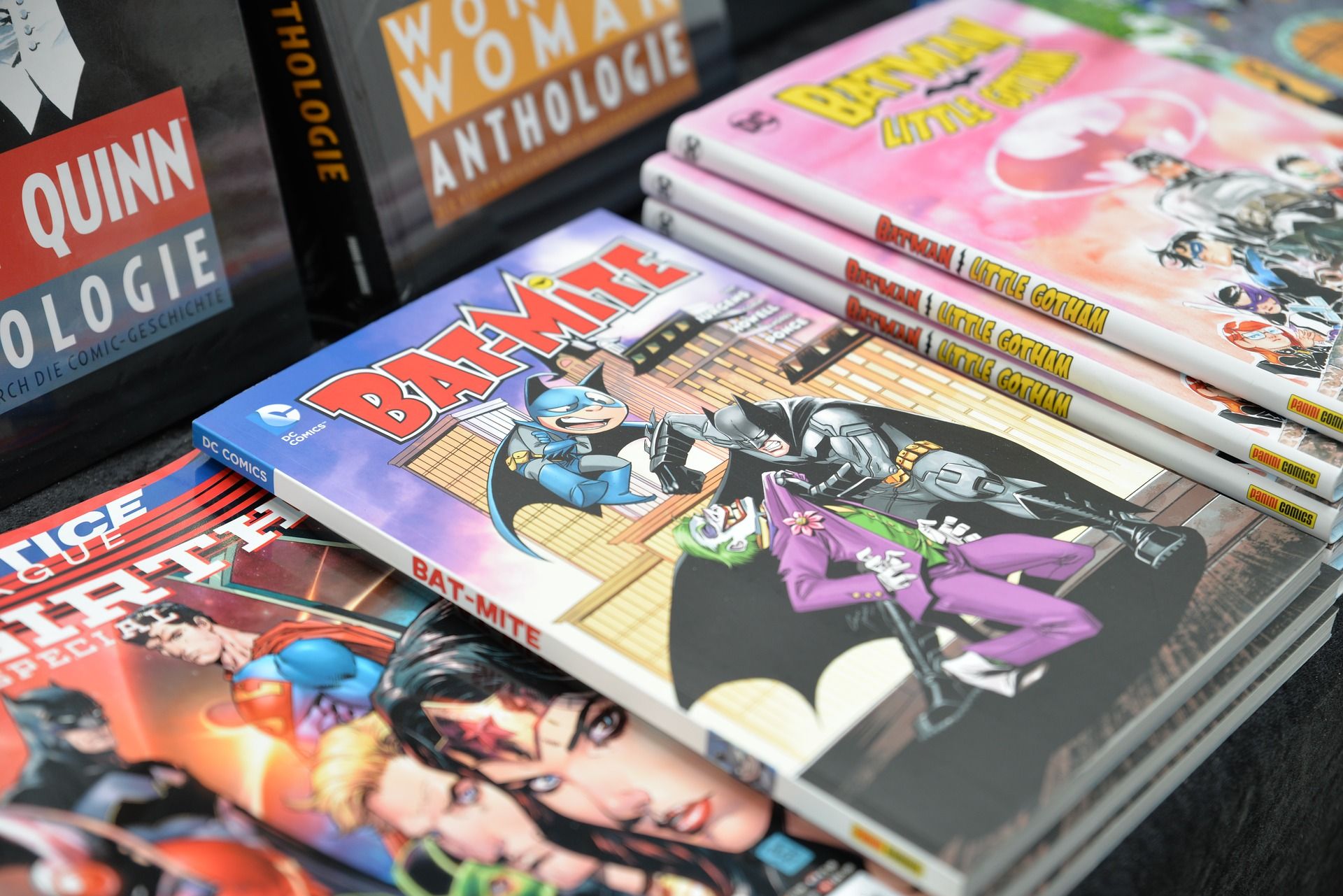 a table stacked with Batman and other comic bind ups