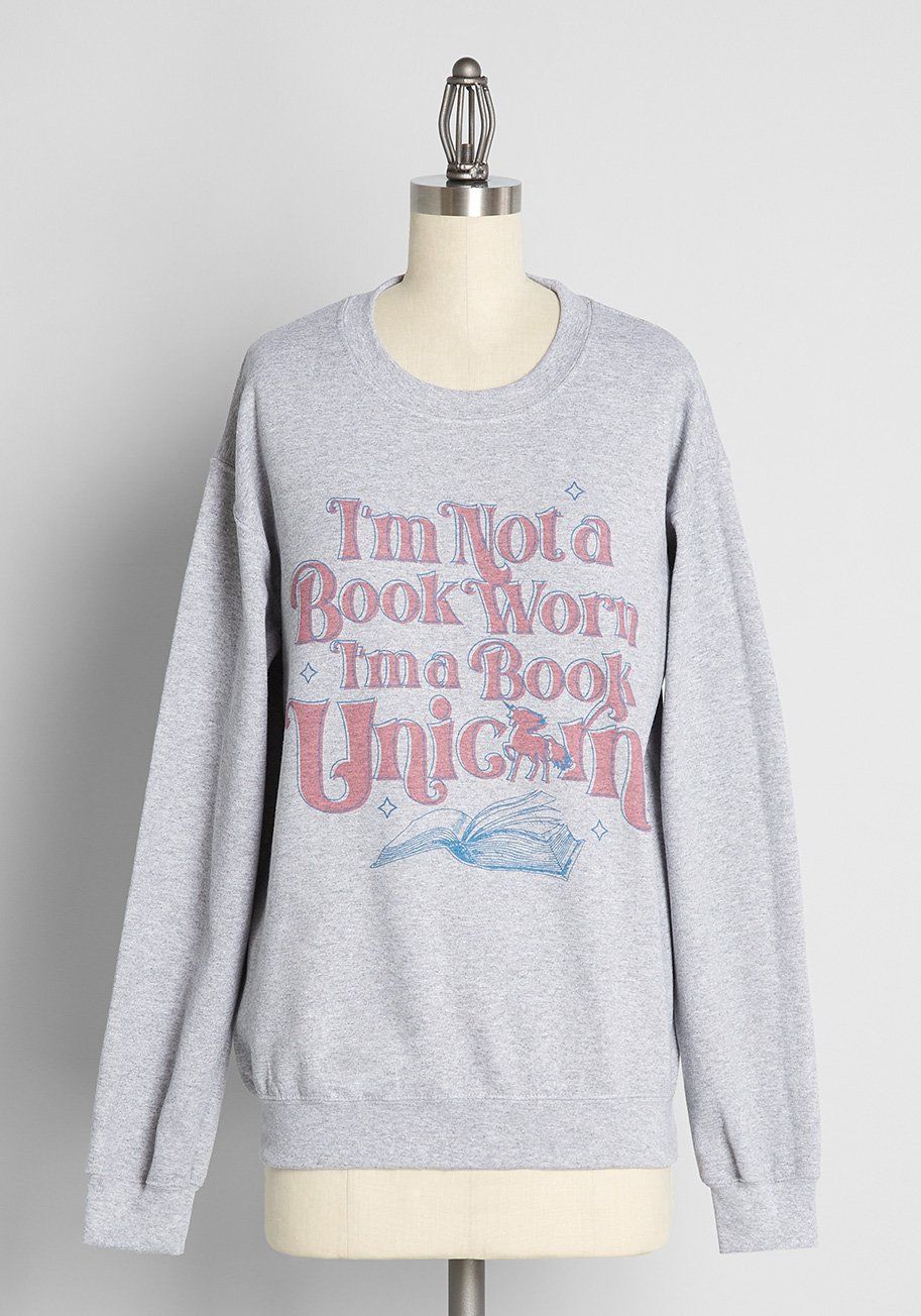 gray sweatshirt with the words "I'm not a book worm, I'm a book unicorn" in pink font. 