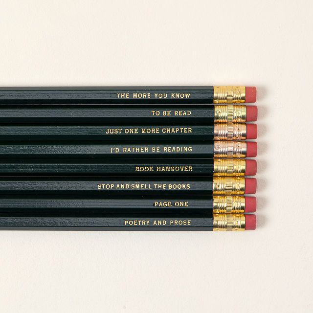 Image of eight dark colored pencils. They each have a bookish saying on them. 
