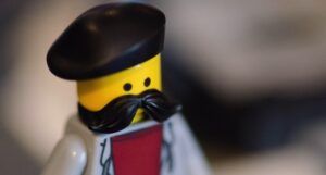 a mini figurine with a large black mustache wearing a black beret
