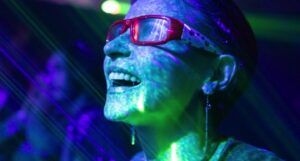 woman smiling with colorful lights shining on her