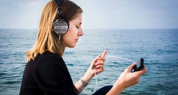 woman with headphones by the water