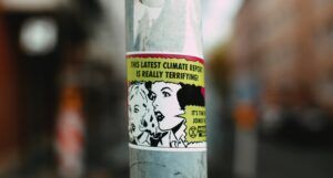 climate sticker on pole that says "the latest climate report is really terrifying"