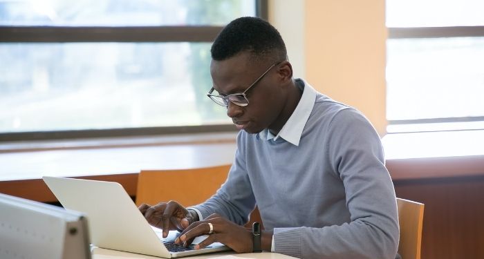 Image of a Black man at a laptop