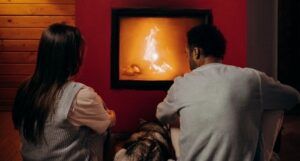 Image of the backs of a couple at a fireplace